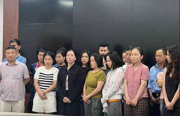 Cựu Viện trưởng Trần Văn Trường (trái), Mai Anh (áo đen thứ 3 hàng đầu trái) cùng các bị can khi bị bắt