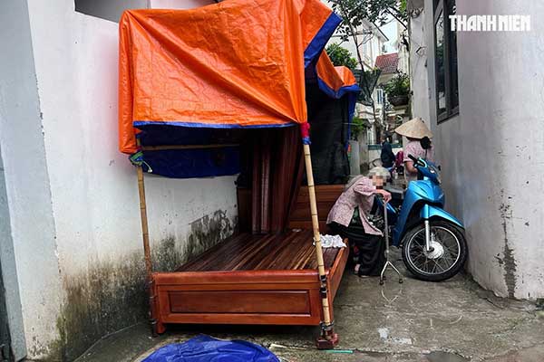 Bà Chi mang chuồng chó, giường và xe máy ra chặn lối đi chung